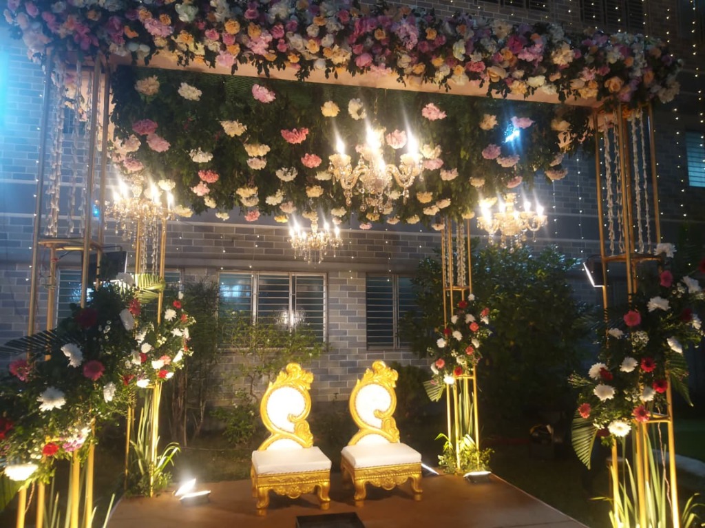 Magnificent outdoor lawn stage with floral ceiling and golden throne seating