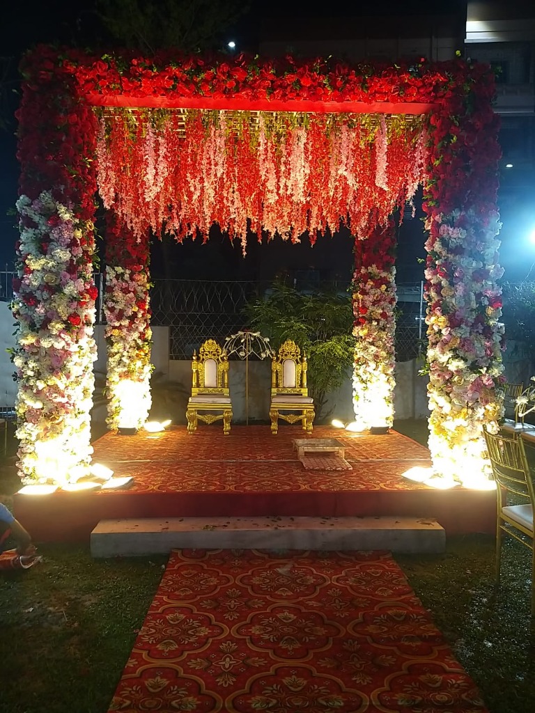 Spectacular red floral hanging ceiling stage with golden throne chairs